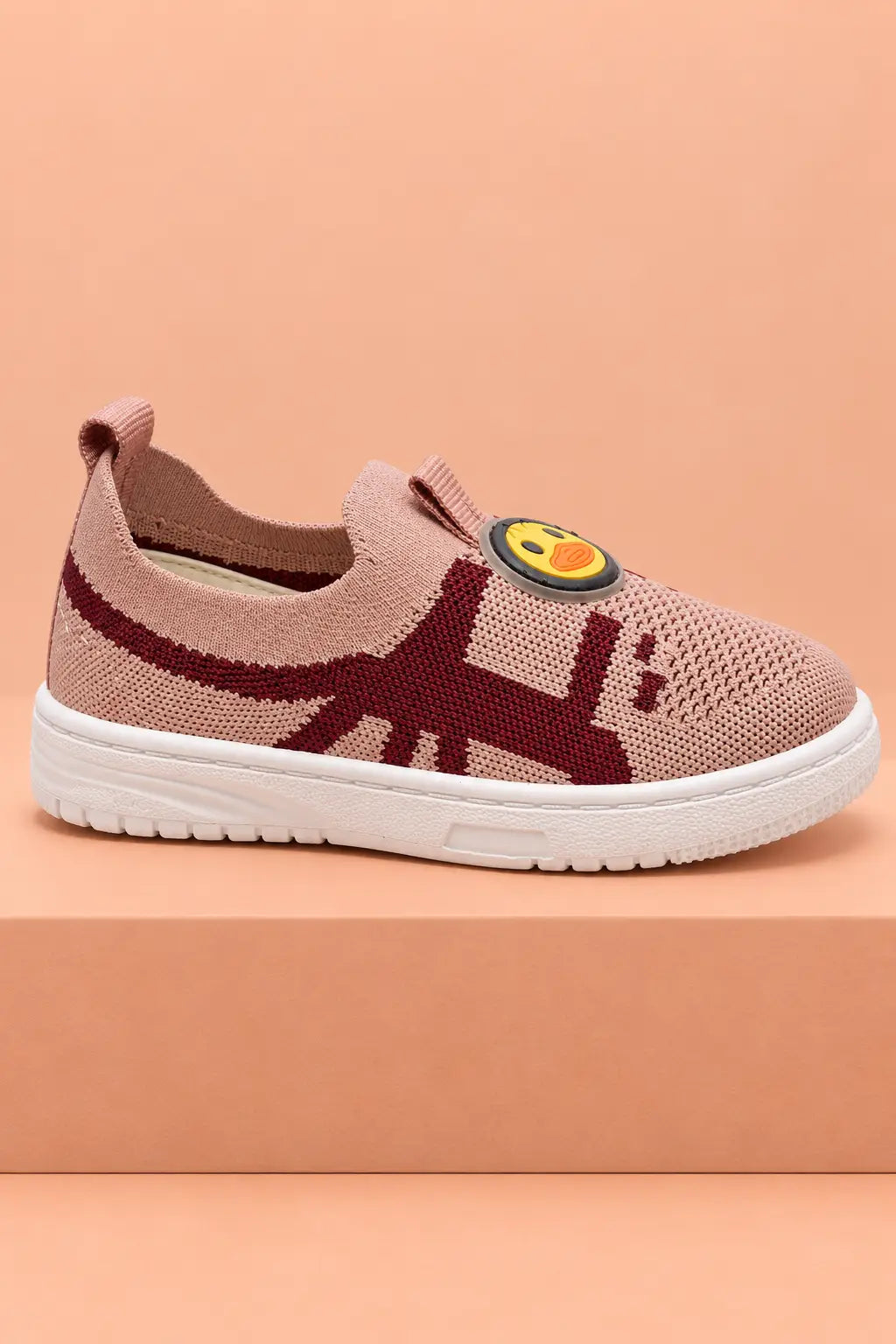 Side view of dusty pink toddler slip-on shoe with white cushioned sole and heel pull tab