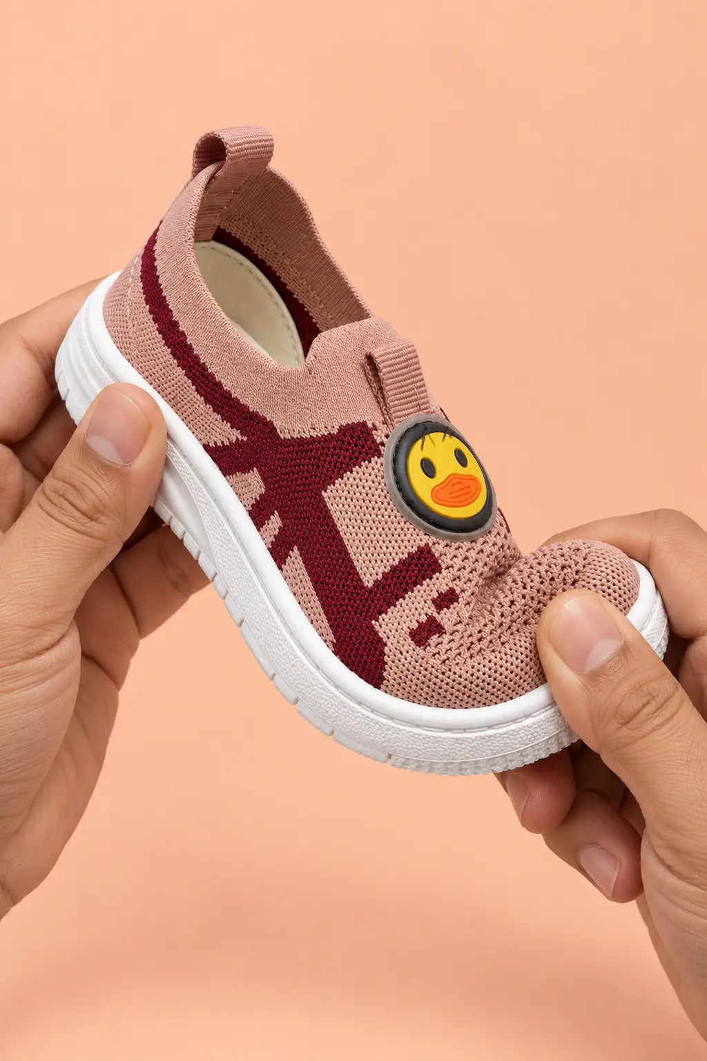 Hands bending toddler sneaker to show soft flexible sole for natural foot movement