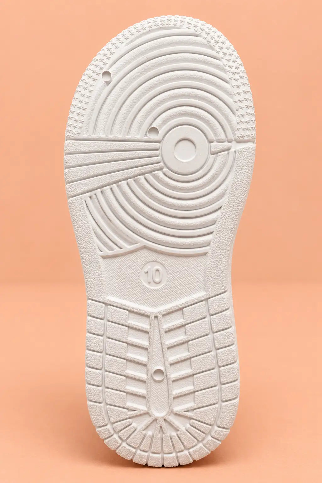 Anti-skid white sole of kids sneakers with circular grip tread pattern