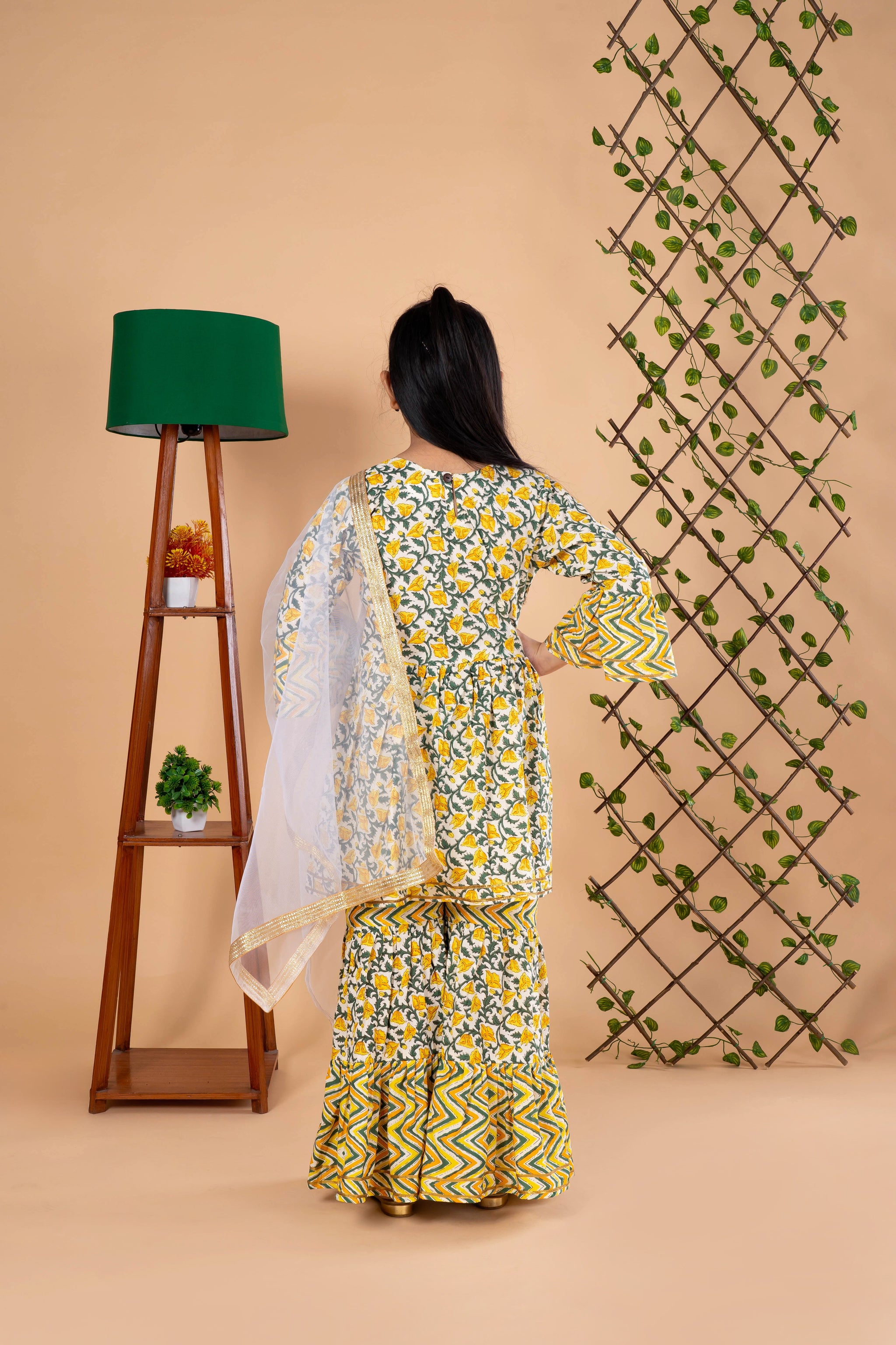 Diwali ethnic wear for girls in yellow floral sibling set (Rakhi) with kurta, palazzo, and net dupatta, perfect for festive celebrations.