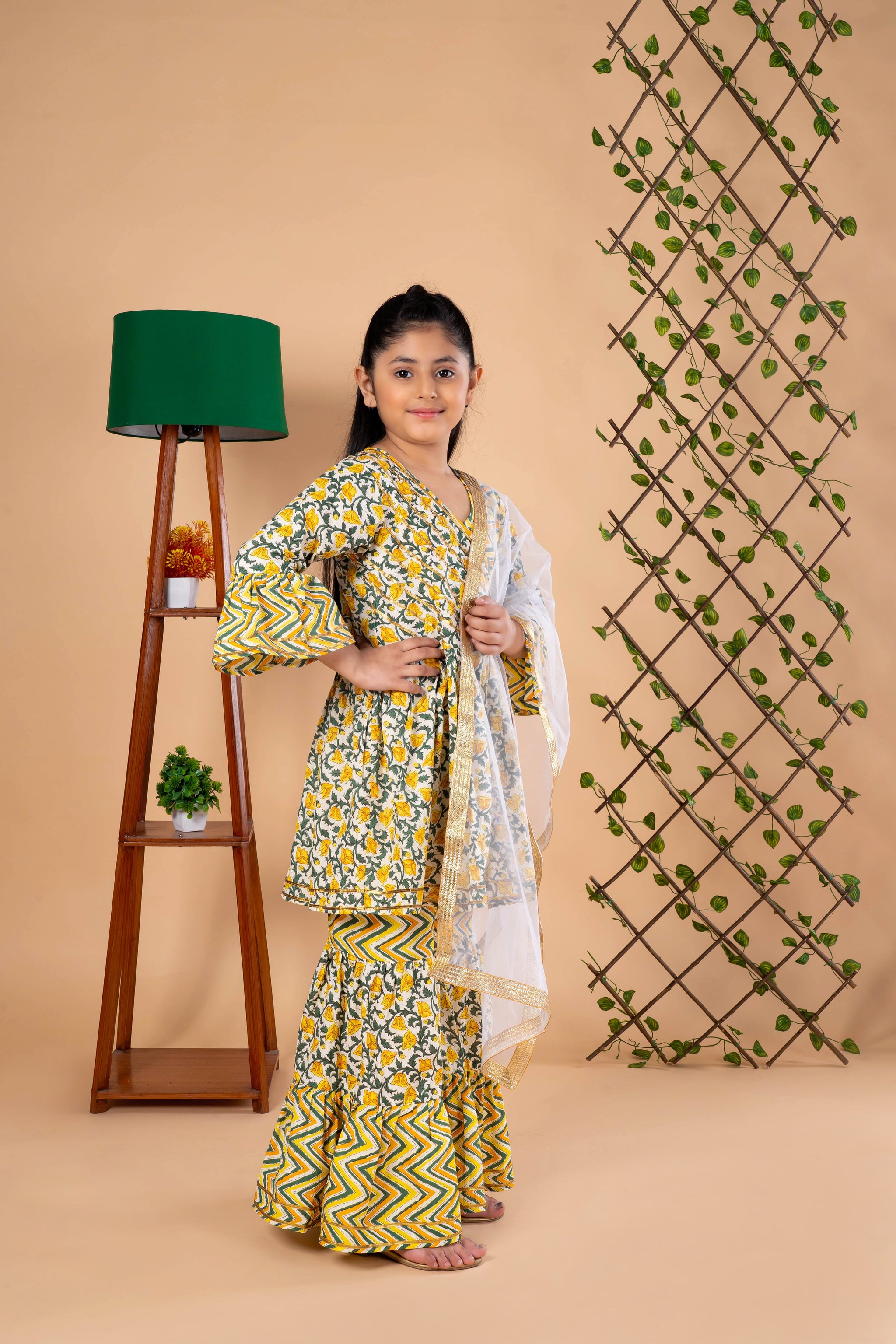Diwali ethnic wear for girls in yellow floral sibling set (Rakhi) with kurta, palazzo, and net dupatta, perfect for festive celebrations.