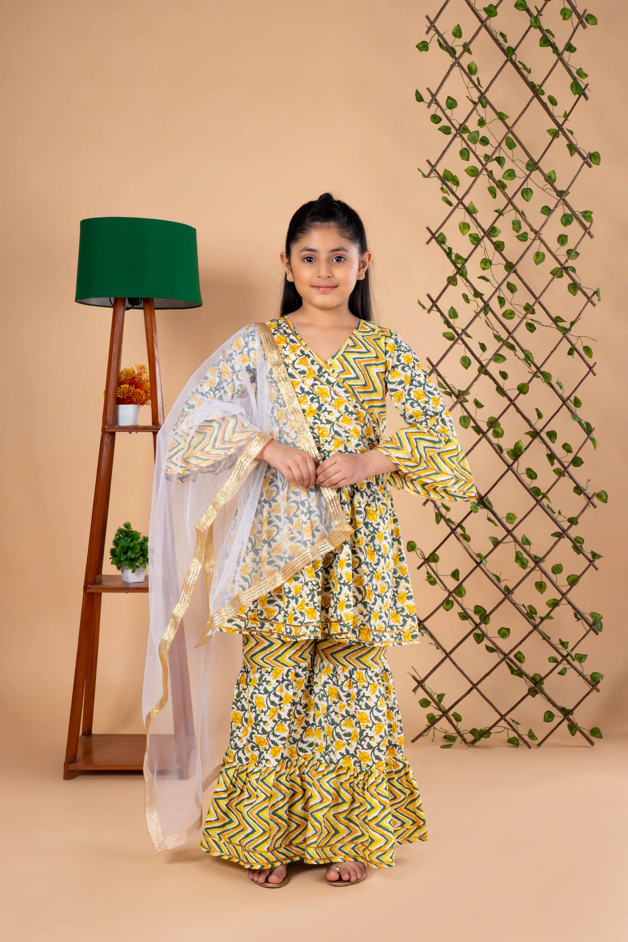 Diwali ethnic wear for girls in yellow floral sibling set (Rakhi) with kurta, palazzo, and net dupatta, perfect for festive celebrations.
