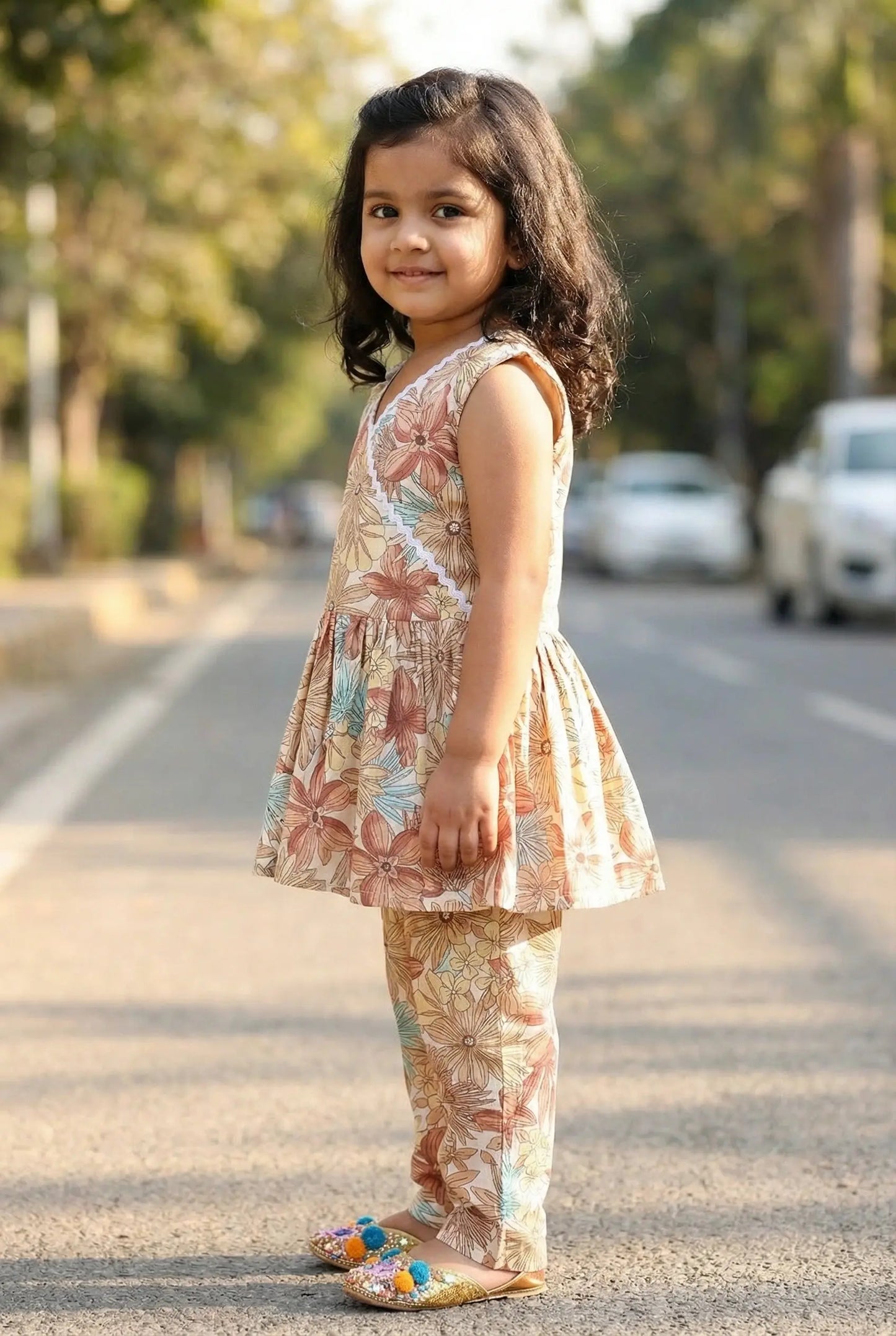 Close-up of white lace trim V-neckline and frill sleeves on girls vintage floral cotton top – Bebe Unicorn coord set