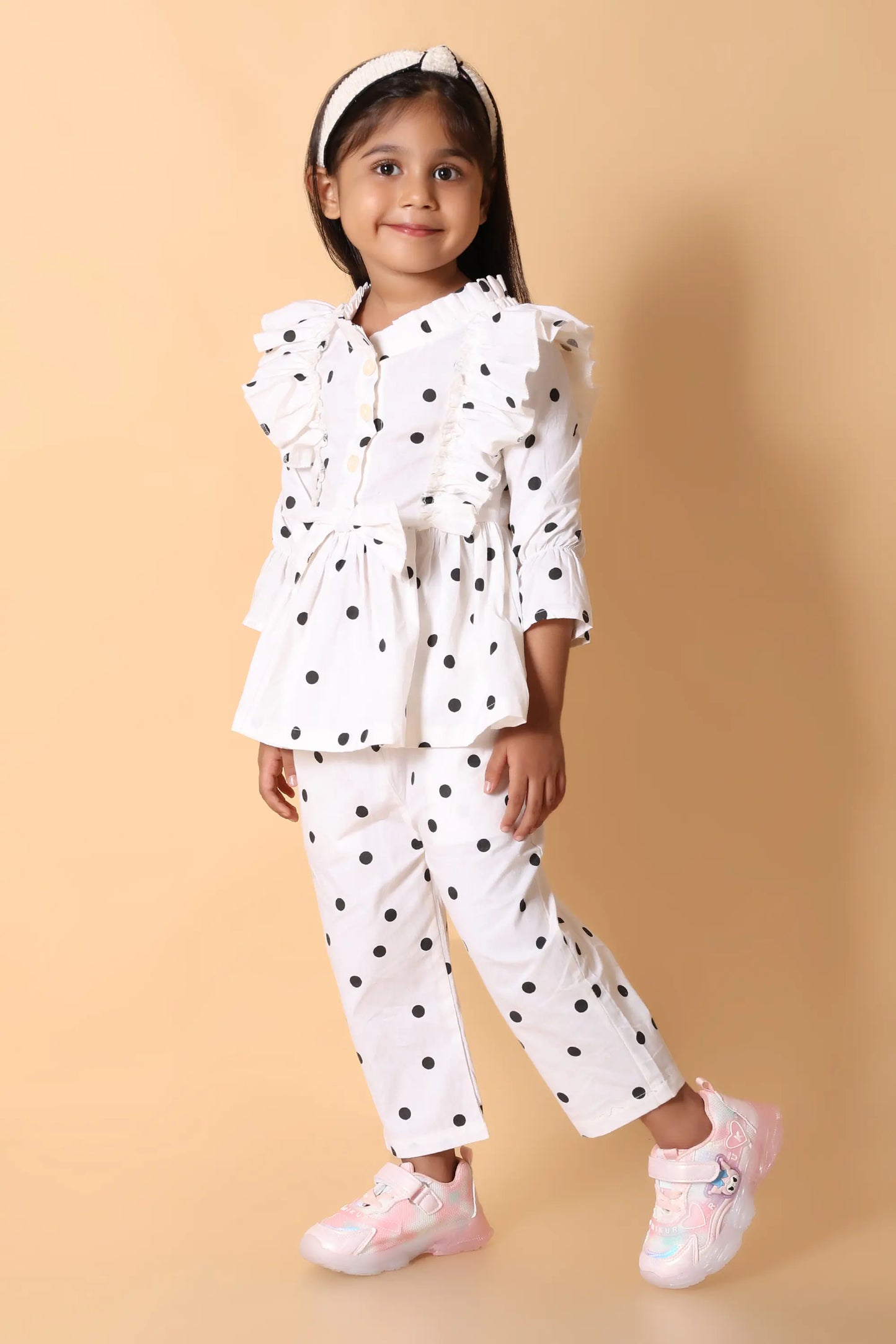 Close‑up – statement bow and ruffle peplum on girls co-ord set