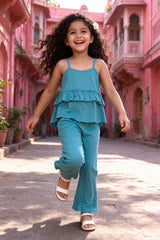Girl wearing girls teal rib-knit ruffle cami top & flared pants coord set, front view