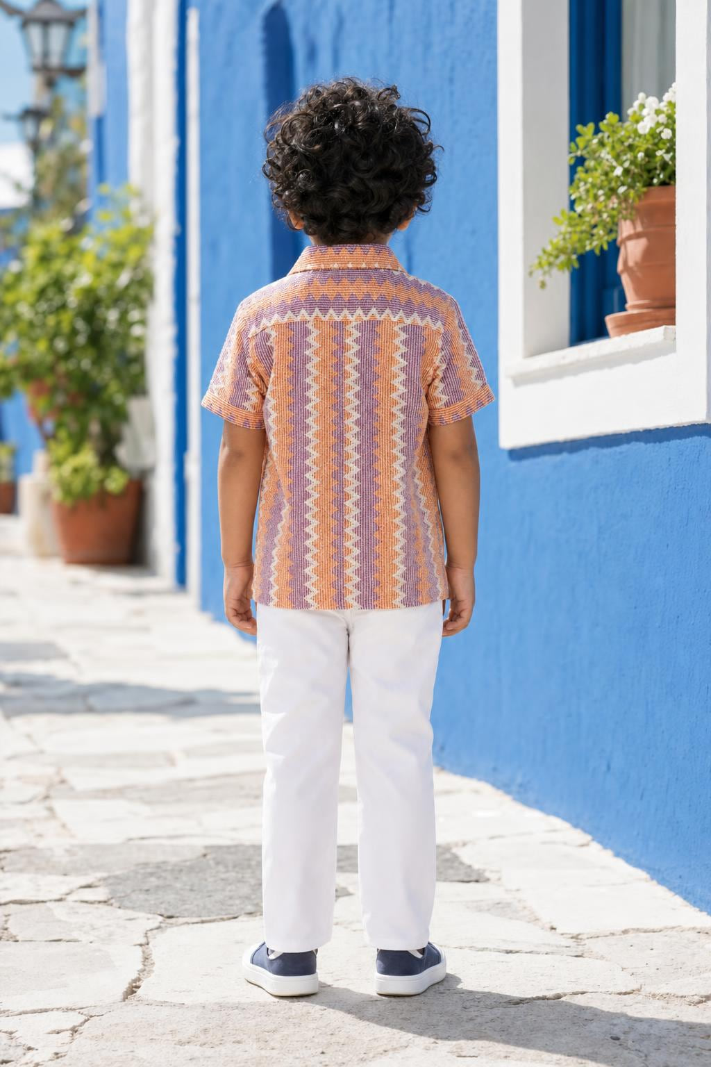 Back view of boys orange and purple zig-zag shirt