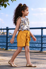 Side view of girls floral frilled top & yellow shorts set