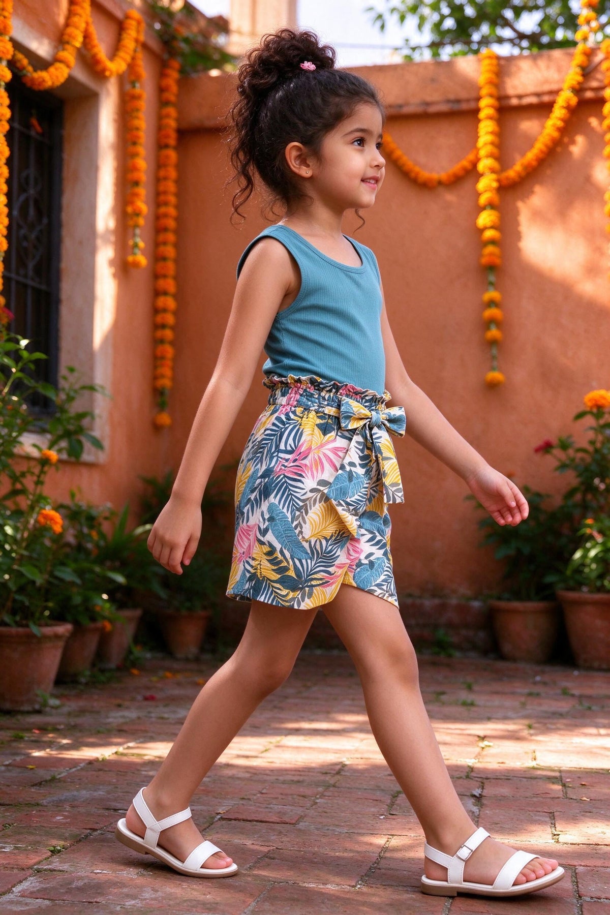 Side view of girls teal top & floral shorts set